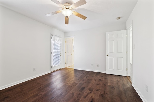 spare room with a ceiling fan, baseboards, and dark wood-type flooring