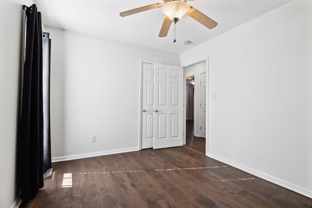 unfurnished bedroom featuring ceiling fan, baseboards, and dark wood-style flooring