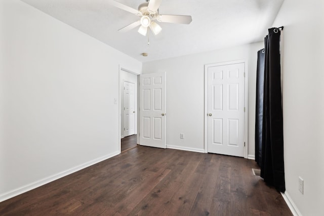 unfurnished bedroom featuring dark wood finished floors, baseboards, and ceiling fan