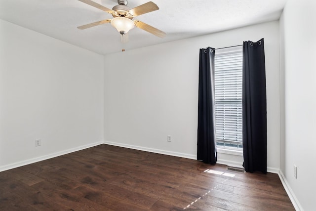 unfurnished room featuring ceiling fan, baseboards, visible vents, and dark wood finished floors