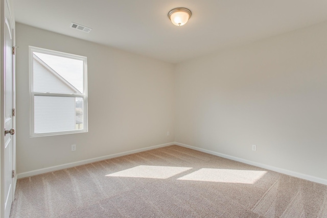 carpeted empty room featuring visible vents and baseboards