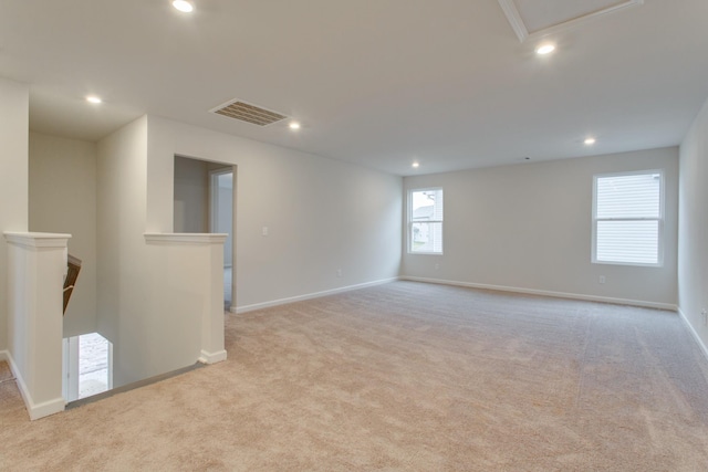 spare room featuring light colored carpet, recessed lighting, visible vents, and baseboards