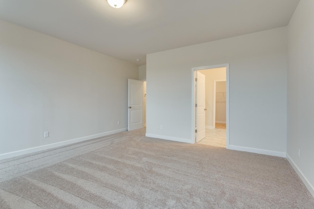 unfurnished bedroom featuring light colored carpet and baseboards