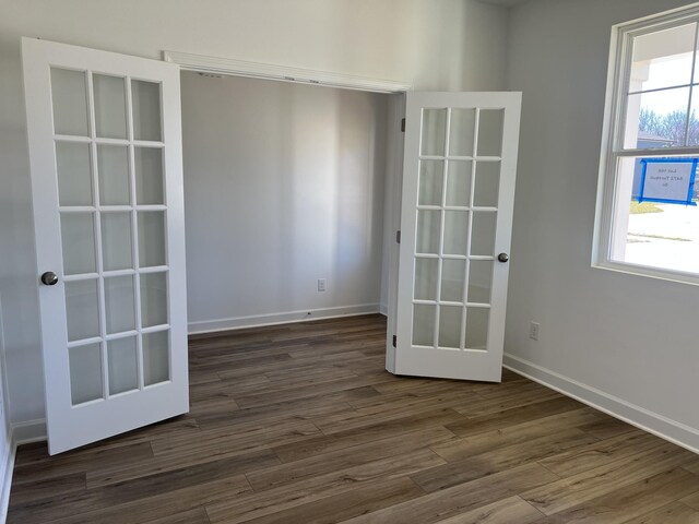 spare room with dark wood-style floors and baseboards