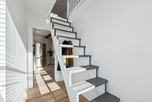 staircase featuring a high ceiling and wood-type flooring