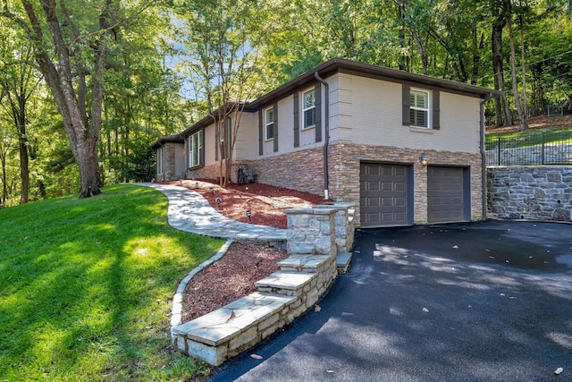 view of side of home featuring a garage and a yard