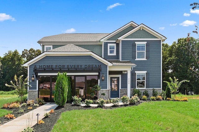 craftsman house featuring stone siding and a front lawn