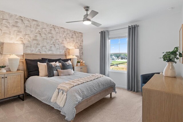 bedroom with a ceiling fan, light colored carpet, and baseboards