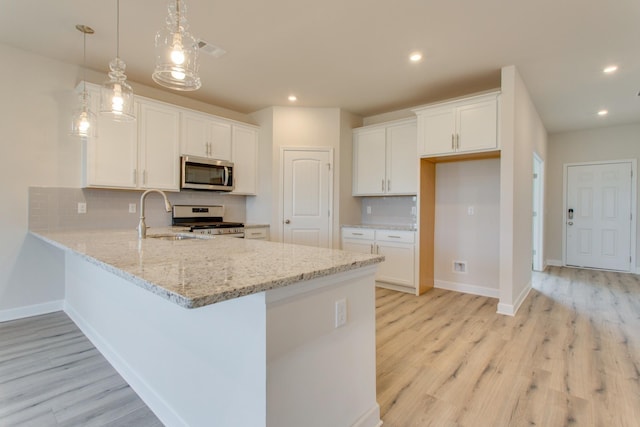 kitchen featuring visible vents, decorative backsplash, a peninsula, stainless steel appliances, and white cabinetry