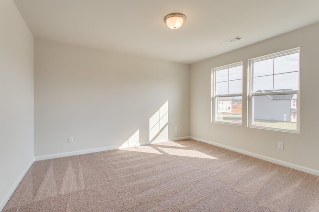 empty room featuring baseboards, visible vents, and carpet flooring