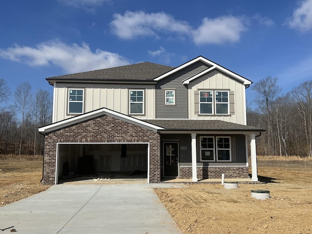 view of front of home with a garage, concrete driveway, board and batten siding, and brick siding