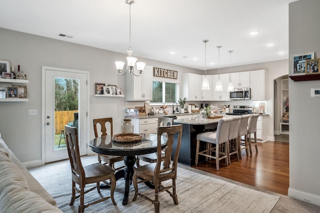 dining room featuring hardwood / wood-style flooring and a chandelier