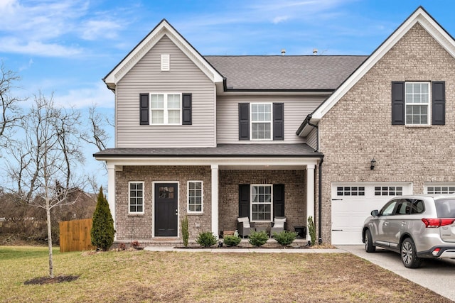 view of property with a front yard, a garage, and a porch