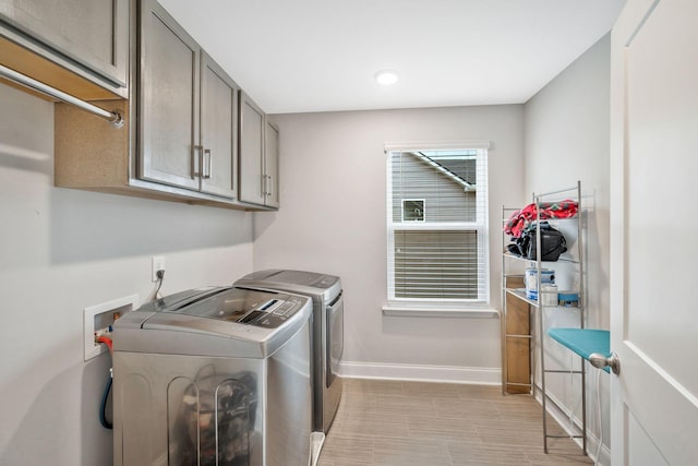 washroom with cabinets and washing machine and dryer