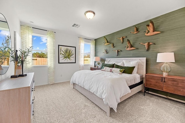 bedroom with visible vents, light carpet, baseboards, and multiple windows