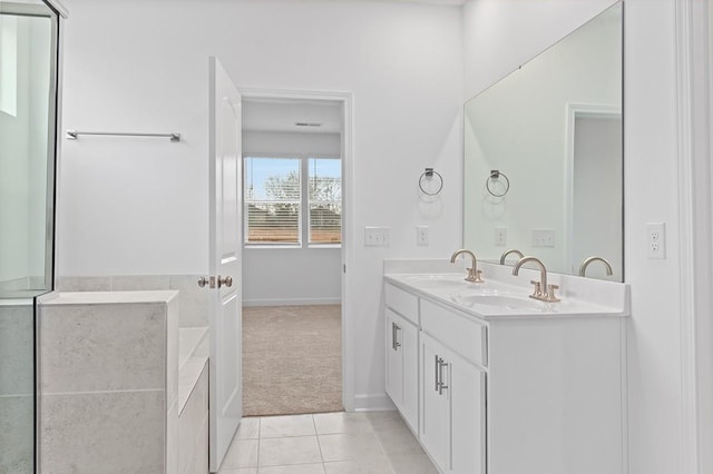 bathroom featuring tile patterned flooring, a sink, and double vanity