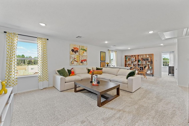 carpeted living area with attic access, visible vents, baseboards, and recessed lighting