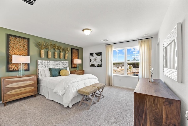 bedroom with light colored carpet, visible vents, and baseboards