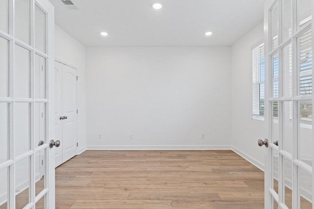 empty room featuring french doors, recessed lighting, visible vents, light wood-style floors, and baseboards