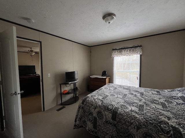 bedroom with ornamental molding, carpet, and a textured ceiling