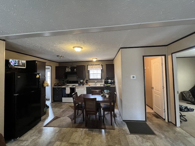 dining room with sink, ornamental molding, and a textured ceiling