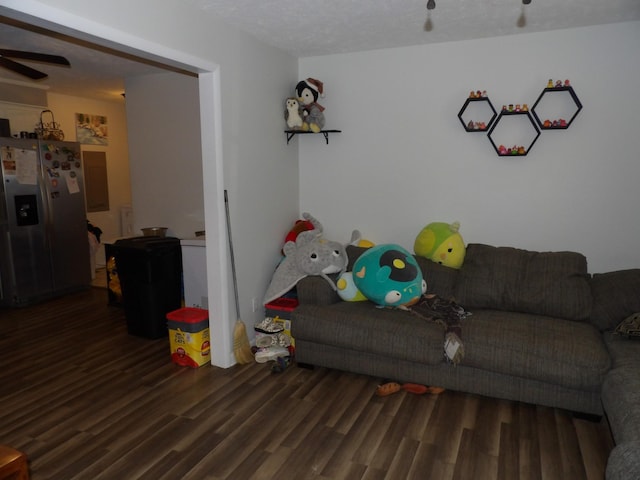 living room featuring a textured ceiling, dark hardwood / wood-style floors, and ceiling fan