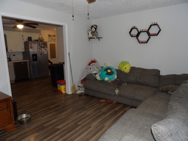 living room featuring ceiling fan, a textured ceiling, and dark hardwood / wood-style flooring