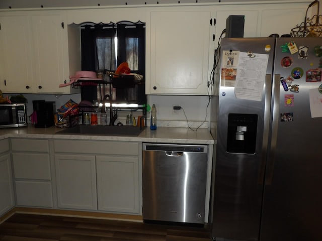 kitchen featuring white cabinetry, stainless steel appliances, and dark hardwood / wood-style flooring