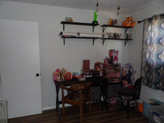 dining space with a textured ceiling and dark hardwood / wood-style floors