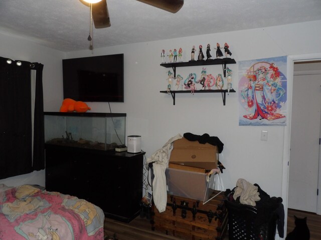 bedroom featuring ceiling fan, a textured ceiling, and hardwood / wood-style floors