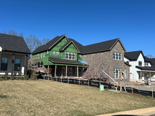 rear view of property featuring a lawn