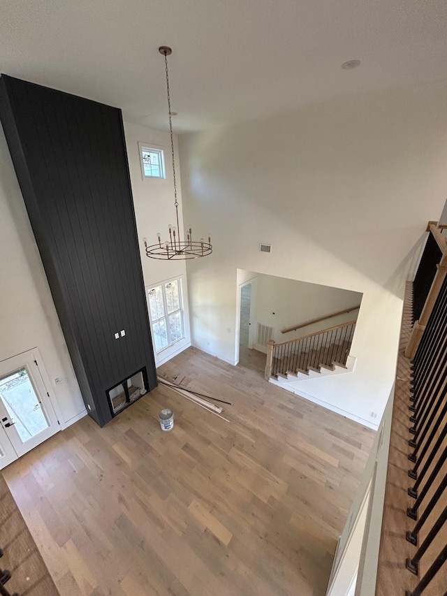 4928 Elmview Ct, Smyrna, TN 37167 - unfurnished living room with visible vents, wood finished floors, a towering ceiling, and a chandelier