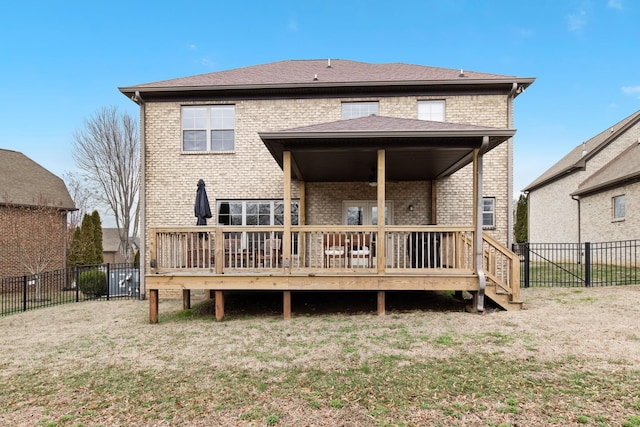 back of property with a yard and a wooden deck