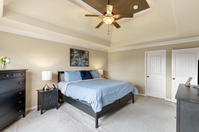 carpeted bedroom with a raised ceiling, ceiling fan, and ornamental molding