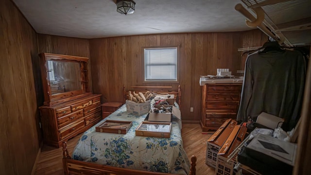 bedroom featuring light wood-type flooring and wooden walls