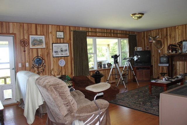 living room with hardwood / wood-style flooring and wood walls