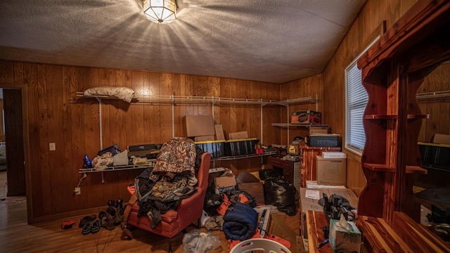 interior space featuring a textured ceiling, wooden walls, and wood-type flooring