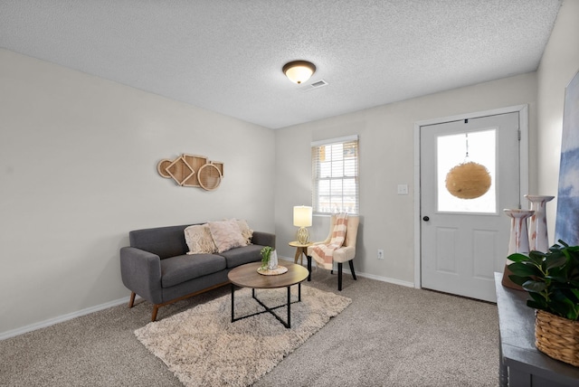 carpeted living room featuring a textured ceiling