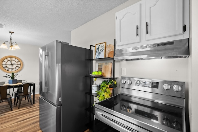 kitchen featuring light hardwood / wood-style floors, a textured ceiling, appliances with stainless steel finishes, white cabinets, and a chandelier