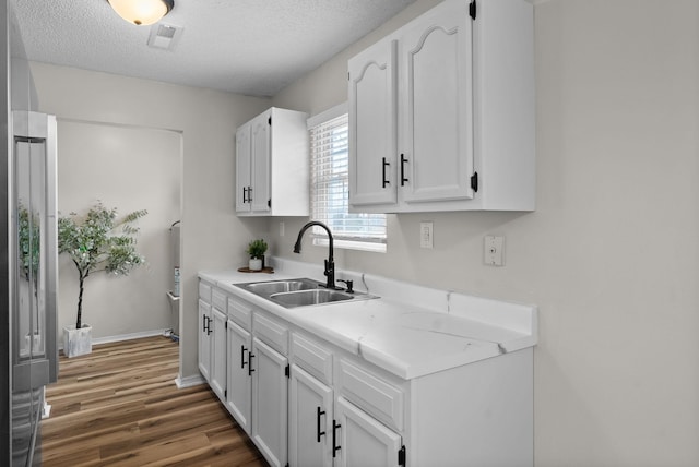 kitchen featuring dark hardwood / wood-style flooring, sink, white cabinetry, and a textured ceiling