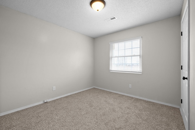 empty room featuring carpet floors and a textured ceiling