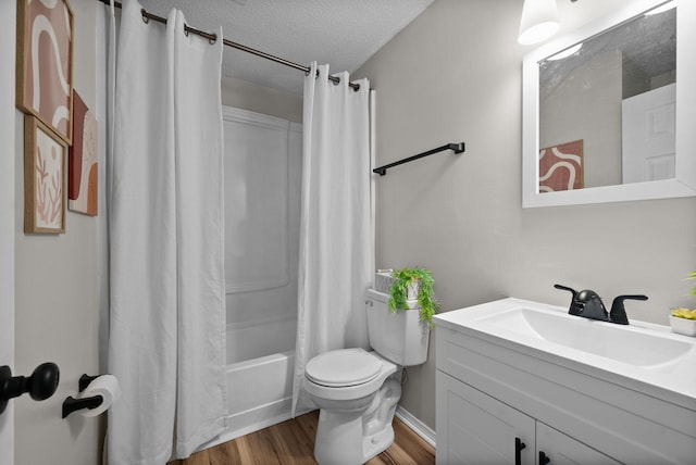 full bathroom featuring shower / bathtub combination with curtain, toilet, wood-type flooring, a textured ceiling, and vanity