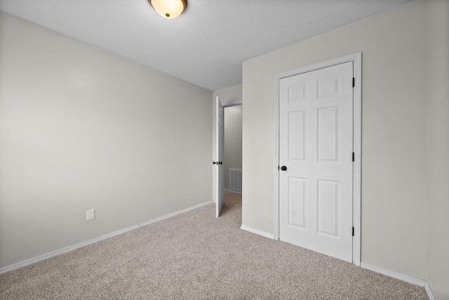 unfurnished bedroom with light carpet and a textured ceiling