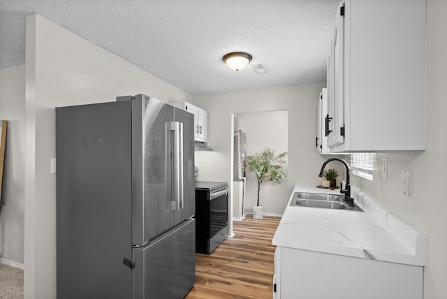 kitchen featuring white cabinetry, a textured ceiling, sink, and stainless steel appliances