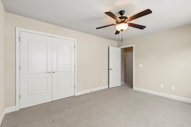 unfurnished bedroom with ceiling fan, a closet, and light colored carpet