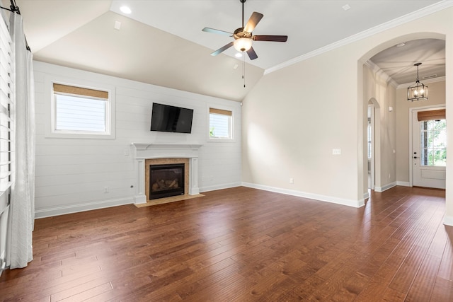 unfurnished living room featuring dark hardwood / wood-style flooring, ornamental molding, ceiling fan with notable chandelier, and lofted ceiling