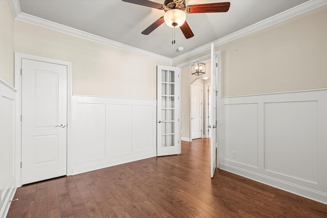 spare room with ceiling fan, ornamental molding, and dark wood-type flooring