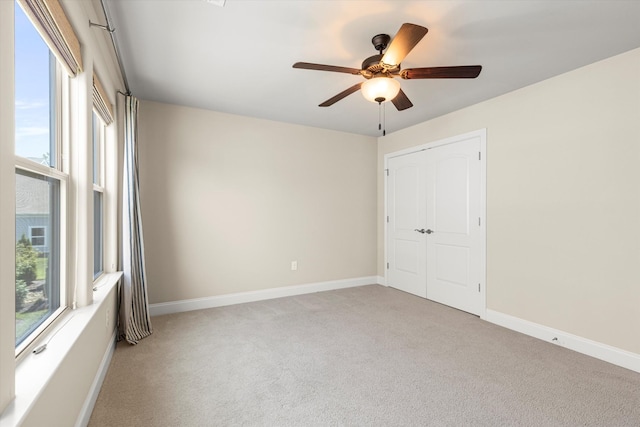 empty room with ceiling fan and light colored carpet