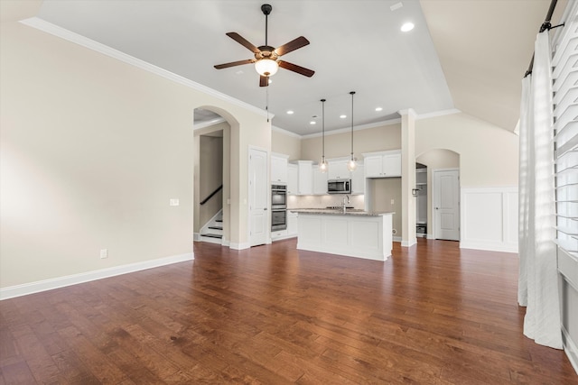 unfurnished living room with dark hardwood / wood-style flooring, ceiling fan, sink, and ornamental molding