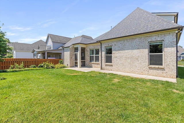 back of house featuring a patio and a yard